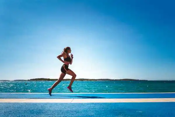 Woman running showing strong leg muscle Ruislip